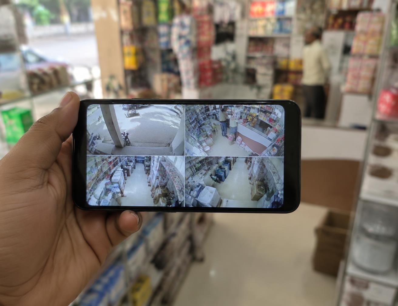 Phone showing a four camera CCTV live view inside a shop